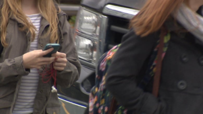 Students walking holding phones