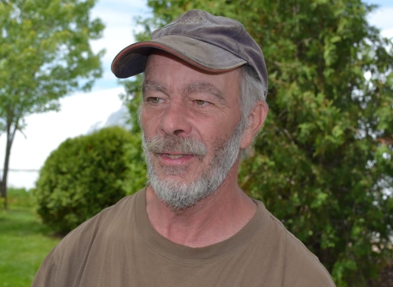 A man with a grey beard wearing a baseball cap.