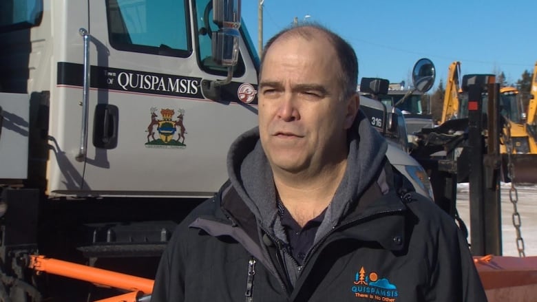 Medium shot of man speaking in front of Town of Quispamsis truck