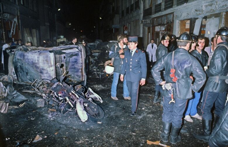 Firemen standing by the wreckage of a car and motorcycle after a bomb attack at a Paris synagogue on October 3, 1980 that killed four people. A Canadian court ruled on June 6, 2011 to extradite accused bomber Hassan Diab to France to face prosecution, but warned the government's case was 