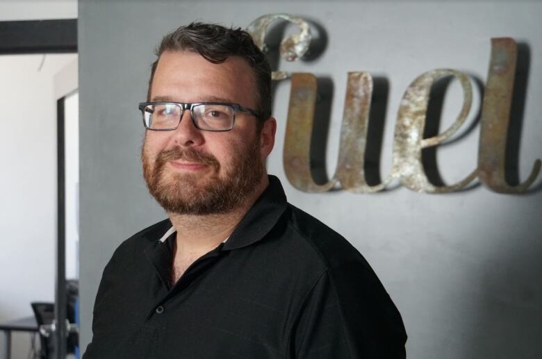 man in a black shirt, with a beard and glasses