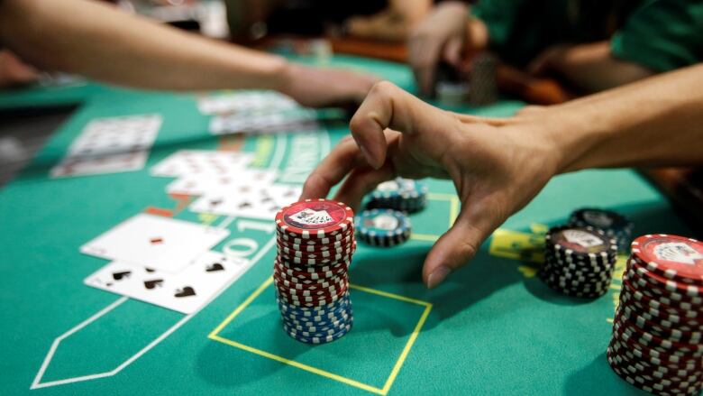 A person reached for chips during a poker game. 