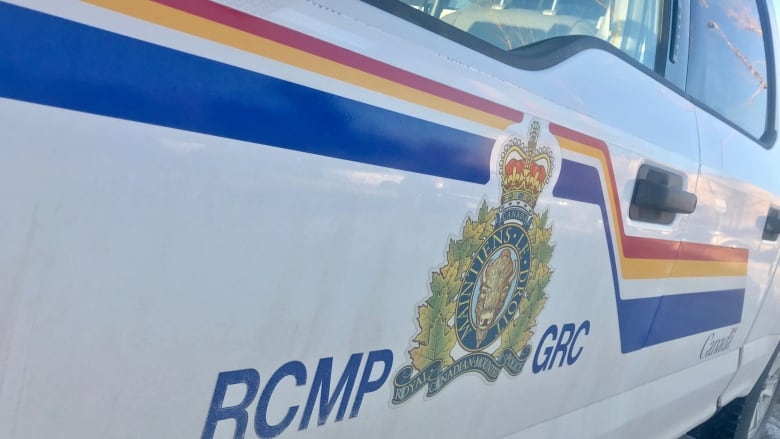 The logo of the RCMP is seen on the side of a vehicle. There is a buffalo head in the logo and the French phrase 