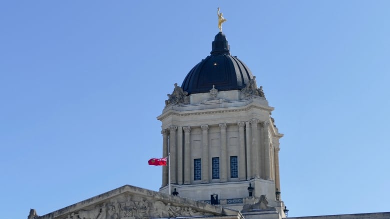 The domed top of a building is seen with a golden statue