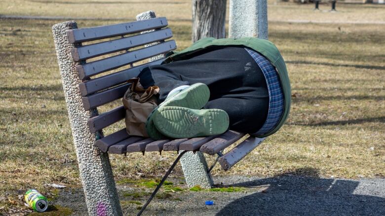 A man sleeps on a bench