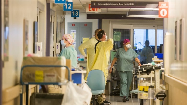 Nurses inside a hospital hallway.