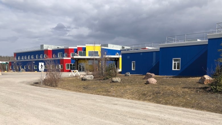 A long blue building with some yellow and red sections 