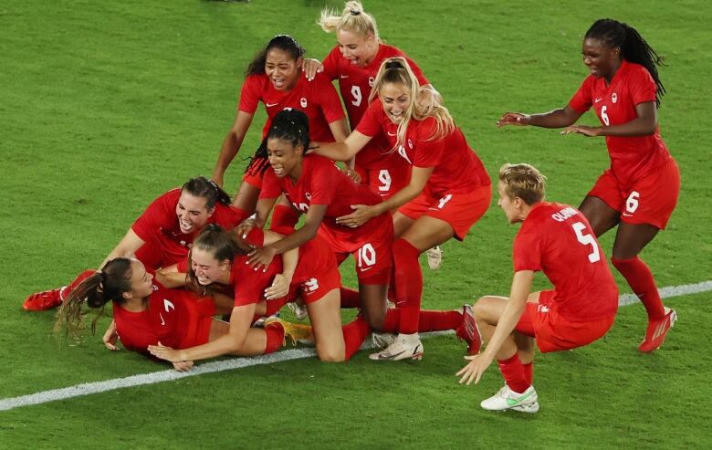 Julia Grosso of Canada celebrates with teammates after scoring the winning penalty in the shootout of the gold medal game at the Tokyo Olympics.