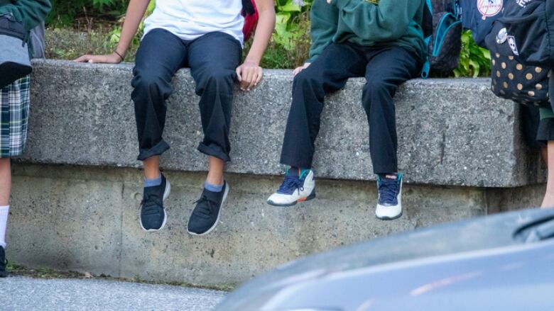 Students wait outside St. Patrick's high school before the first day of classes on Sept. 7, 2021. Former teacher, Robert Lavergne, taught at that school. 