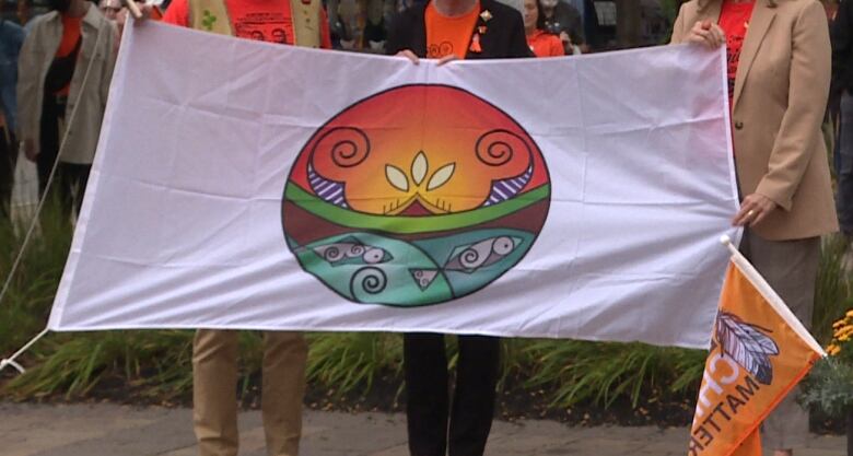 Three people hold a flag.