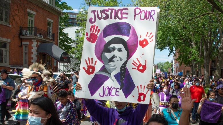 Protesters hold up a sign that reads 'Justice for Joyce.'