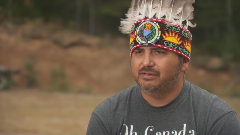 A man wears traditional Wolastoqey chief's headdress.