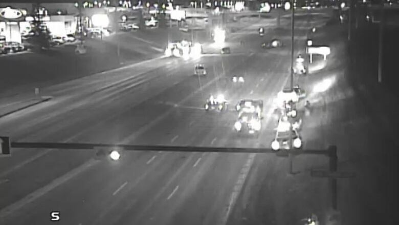 A black and white photo shows the headlights of cars on Macleod Trail where the crash took place.