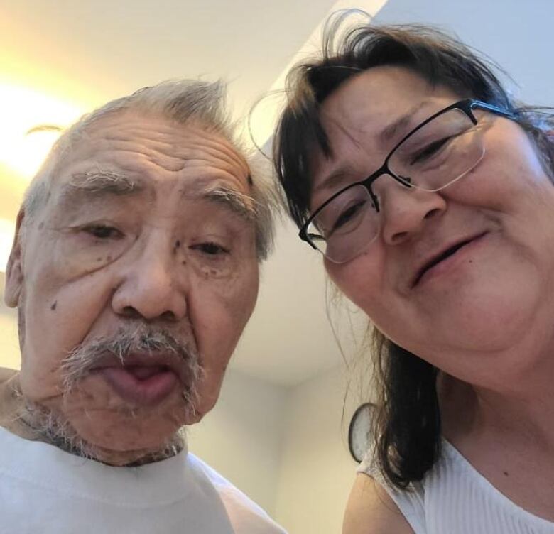 An elder sitting beside his daughter