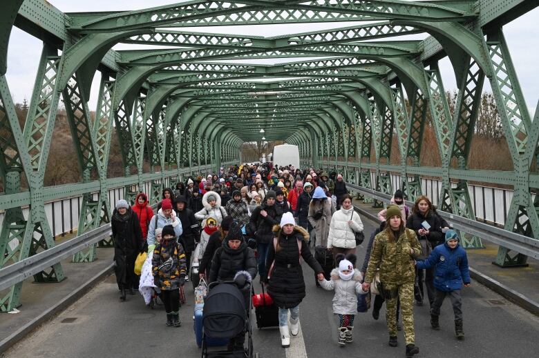 People walk across a bridge.