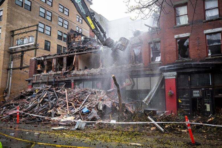 A burned down building with dust rising from it.