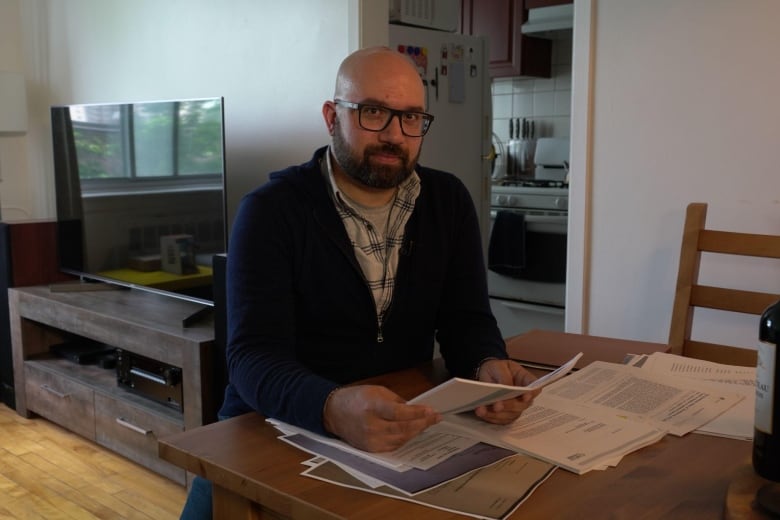 A man sitting in his apartment, surrounded by legal documents.