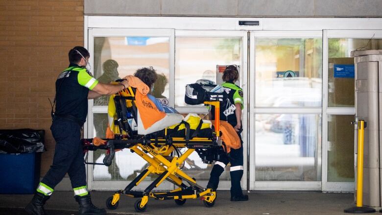 A person is brought into the emergency department of Toronto General Hospital on Aug. 4, 2022, after it issued an alert about staffing shortages in its critical care unit in Toronto.