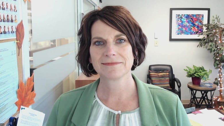 A woman with short hair wearing light green