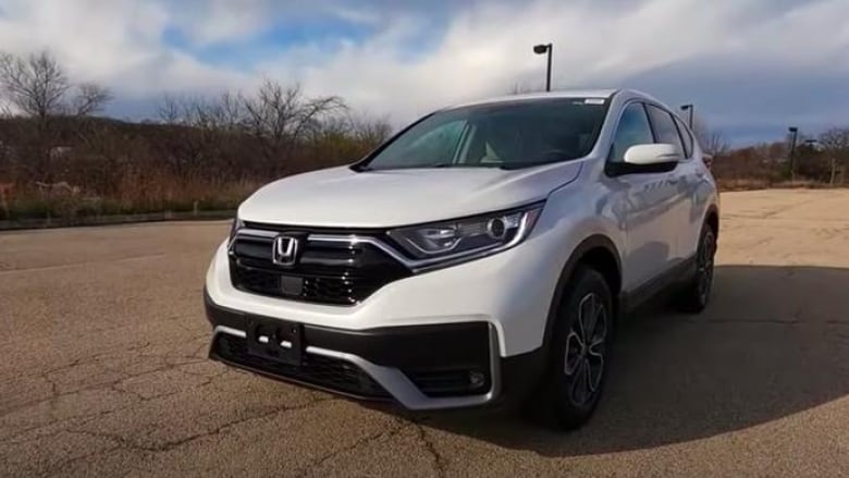 A white Honda SUV in an empty parking lot. 