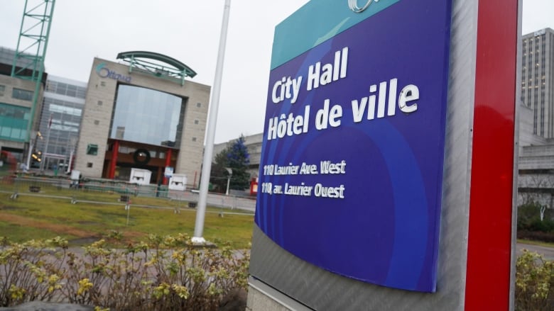 A blue sign for a city hall building.