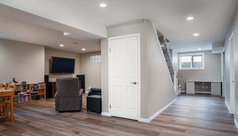 A basement suite in Calgary with a staircase and a living room area. 