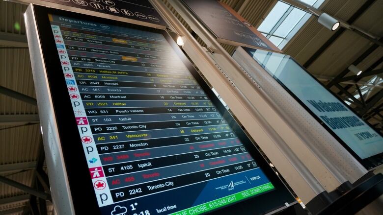 A flight board with cancelled and delayed flights listed.