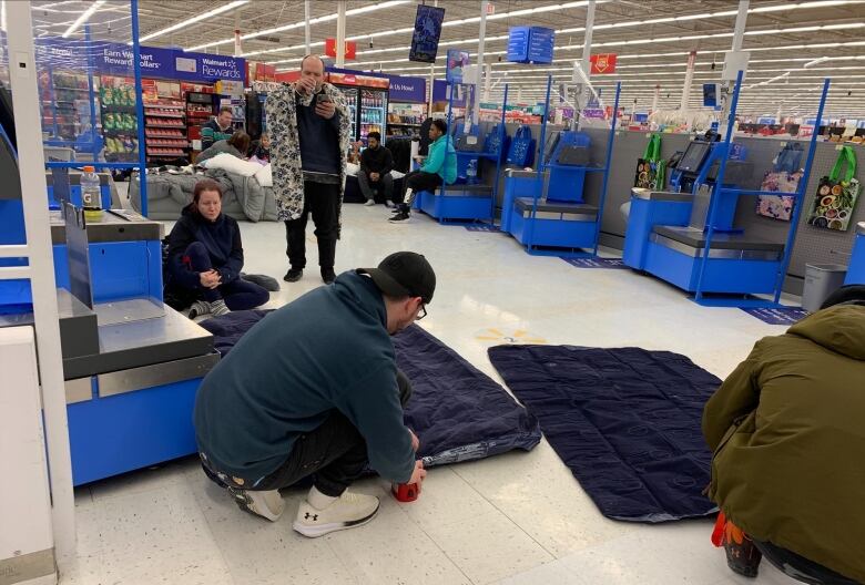 People stranded at a Walmart set up air mattresses to sleep on in the self check-out area