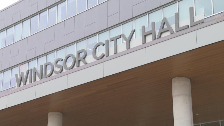 The sign Windsor City Hall sits on top of a building.