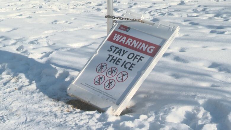 A warning sign on the outside of a storm pond telling people not to skate, play hockey, or walk on it.