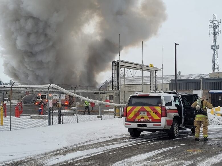 Firefighters at a large industrial fire in winter.