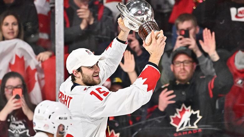 Male hockey player skates with the IIHF World Championship Cup after leading Canada to title victory.