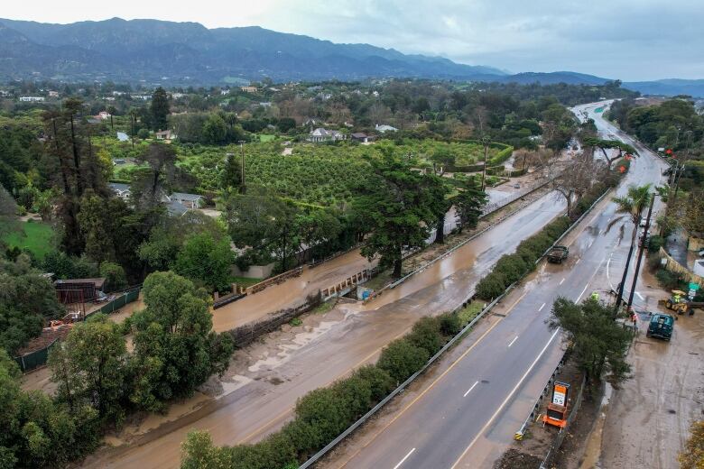 A highway in California is flooded with chocolate-brown muddy water in January of 2023