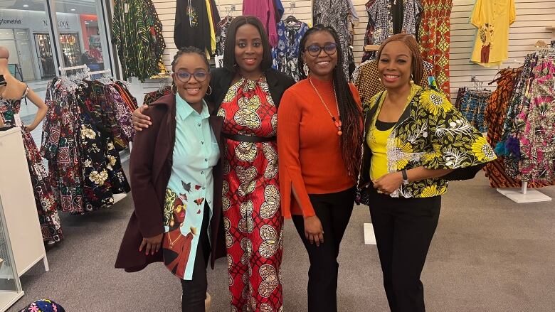 A group of women standing side-by-side in a shop.