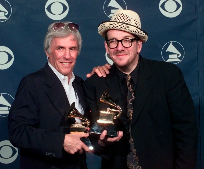 Two men are shown, each holding an award.