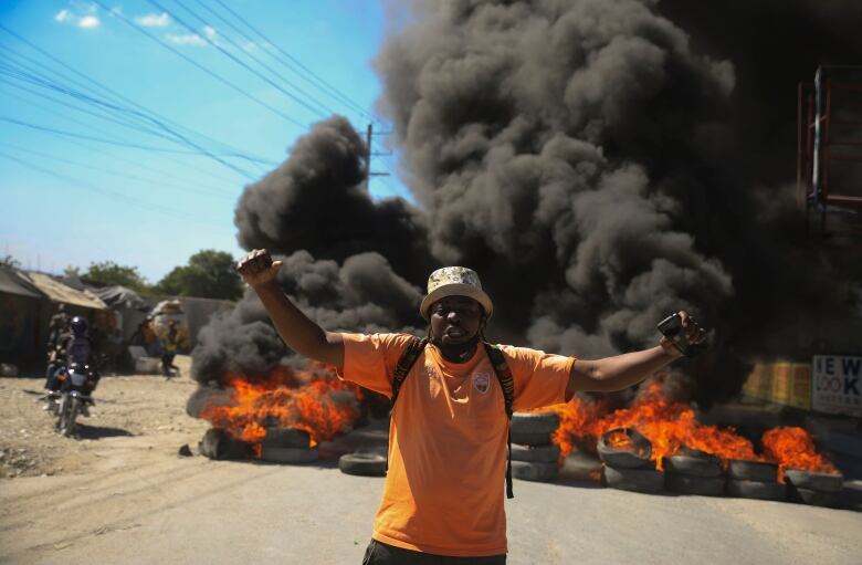 A protester shouts anti-government slogans by a burning barricade set up by members of the police to protest bad police governance in Port-au-Prince, Haiti on Jan. 26, 2023. A wave of grisly killings of police officers by gangs has spurred outrage among Haitians.