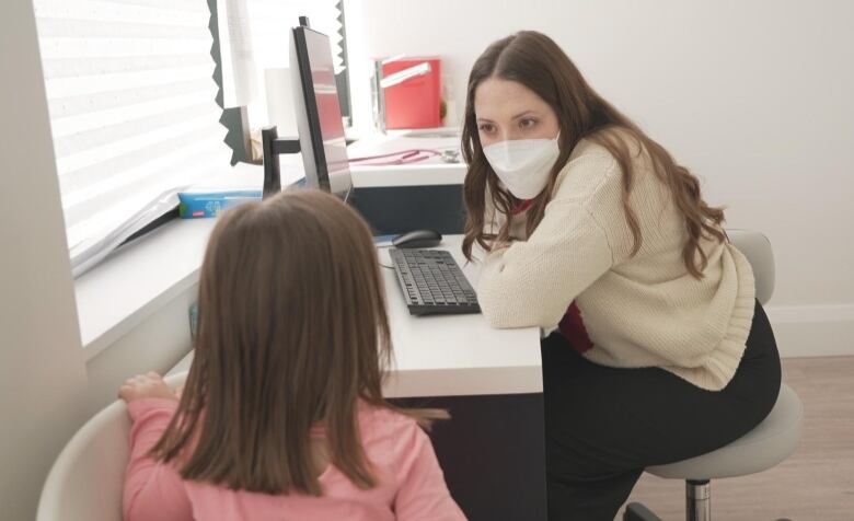 A nurse practitioner is pictured with a three-year-old girl.  