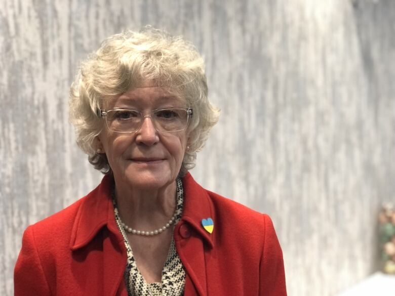 An older woman wearing a red blouse.