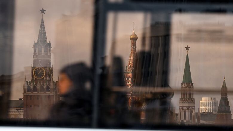 Transit riders pass by the Kremlin's Spasskaya tower and Saint Basil's Cathedral.