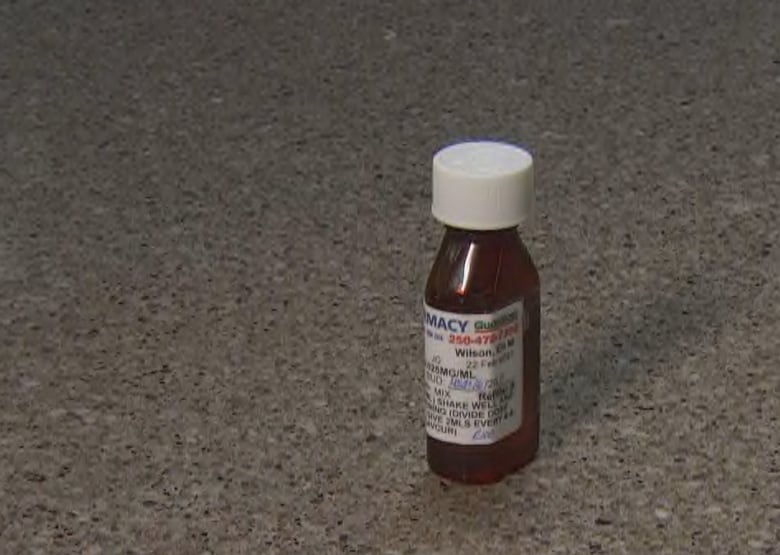 A brown medication bottle with a pharmacy label is shown on a grey granite countertop.