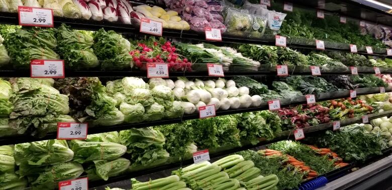 Vegetables are shown in the produce section of a grocery store.