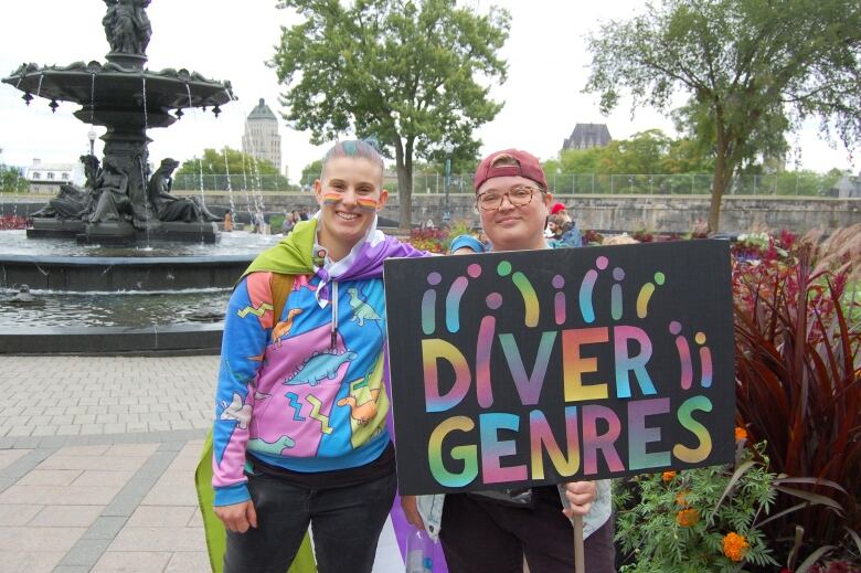 two people at a pride festival holding a sign that says 