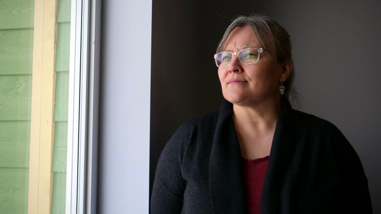 Woman looks through a window.