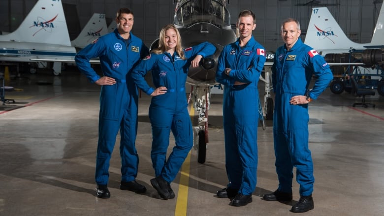 Jeremy Hansen, Jennifer Sidey-Gibbons, Joshua Kutryk and David Saint-Jacques, the four active current astronauts, stand together in front of a jet in an airport hangar.