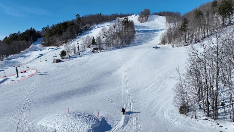 A snowmobile riding up a ski hill.