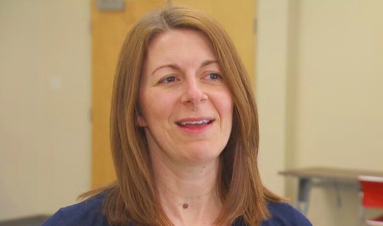 A woman with shoulder-length hair wearing a blue shirt