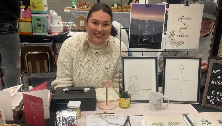 A woman sitting at a homemade craft table is pictured.