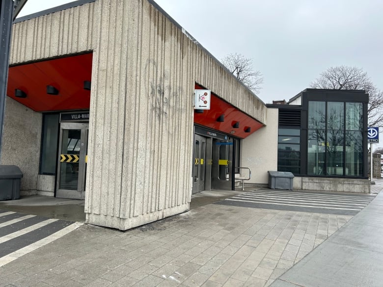 Two entrances of a Metro station pictured on a rainy day. 