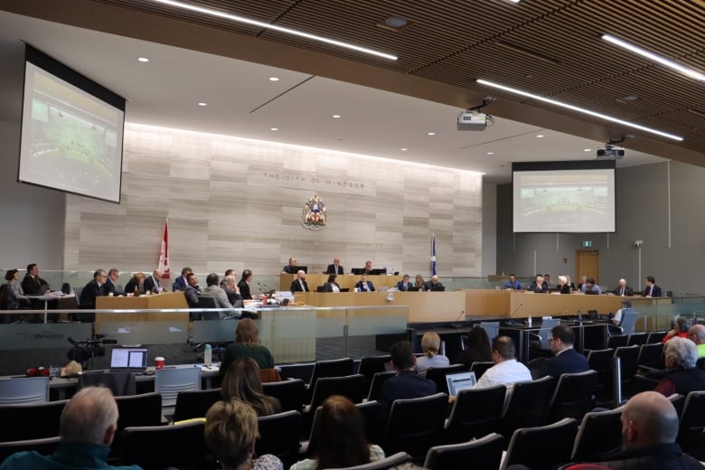 City councillors in chambers, with an audience.