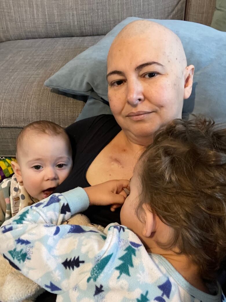 A woman poses with her two sons. 